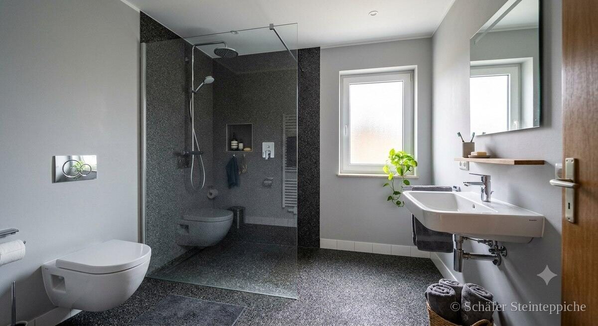 Badezimmer mit anthrazitfarbenem Steinteppich